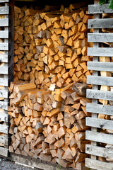 Firewood cut and piled high for sale. Wood is used for Fires in Fireplaces and Camp Fires. Preparation for the winter. Located in northern Italy