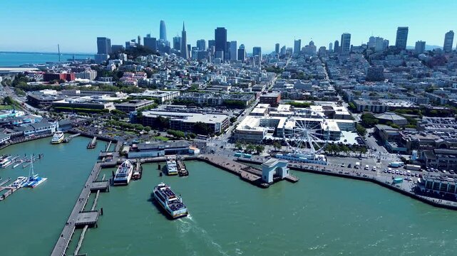 Drone aerial landscape of San Francisco city CBD downtown wharf Embarcadero ship ferry docking at pier 41 bay area with Ferris wheel USA America travel tourism infrastructure