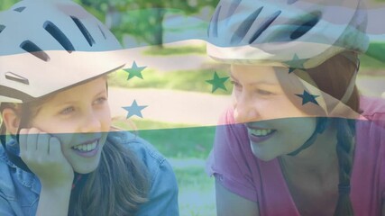 Smiling woman and girl wearing helmets over honduras flag animation - Powered by Adobe