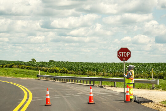 Road worker with stop sign on a rural highway