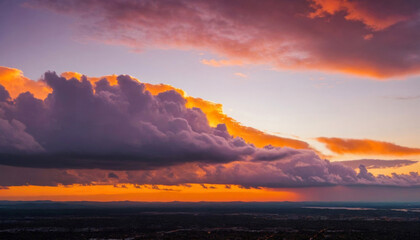Obraz premium Beautiful Purple and Orange Sky with Clouds at Sunset Over a Landscape