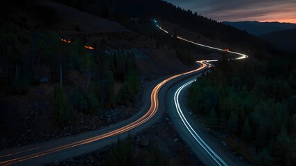 As dusk descended, lights and truck and car tracks were visible circulating between circular ravines on a mountain road.