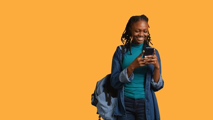 Portrait of overjoyed teenager reading messages on phone, delighted after receiving good news....