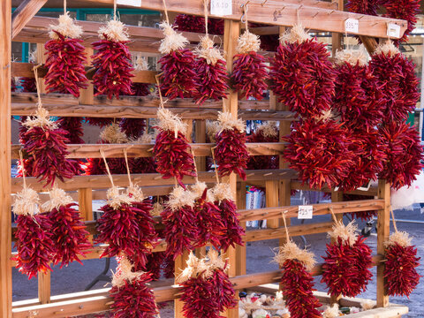 USA, New Mexico, Sante Fe. Large groups of hot red chili peppers hanging on a display in Sante Fe.