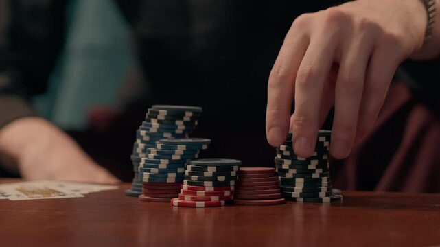 Unknown Caucasian business man guy businessman gamer male hand palm fingers touching counting poker chips tokens playing cards indoor living room or casino bar gambling game victory strategy addiction