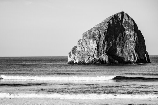 USA, Oregon. Sunrise on the beach, Haystack Rock in Pacific Ocean.