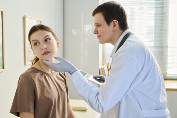 Obraz premium Examining young patient in modern exam room with healthcare professional using stethoscope. Medical tools and equipment visible in background