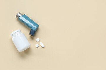 Asthma inhaler and box with pills on beige background