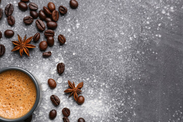 Cup of hot espresso and coffee beans on grey background