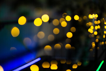 Luzes natalinas douradas, fora do foco, em bokeh, com fundo preto.