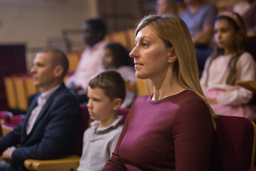 Portrait of a woman with interest watching a concert in the theater