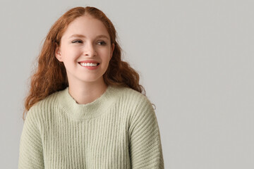 Fototapeta premium Portrait of ashamed young woman on grey background