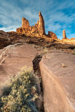 USA, Utah. Zeus and Moses, with clouds, boulders and rabbit brush in Canyonlands National Park