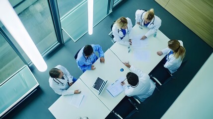 A group of doctors in white coats meet around a table to discuss medical cases.