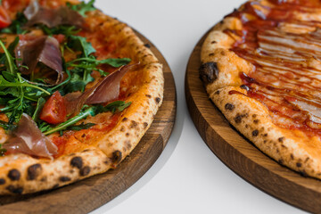 Pizza set with meat and cheese. Pepperoni pizza with arugula and prosciutto. Meat pizza with cheese, cherry tomatoes and hot peppers on a white background