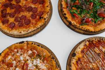 Pizza set with meat and cheese. Pepperoni pizza with arugula and prosciutto. Meat pizza with cheese, cherry tomatoes and hot peppers on a white background