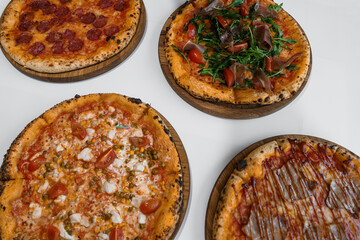 Pizza set with meat and cheese. Pepperoni pizza with arugula and prosciutto. Meat pizza with cheese, cherry tomatoes and hot peppers on a white background
