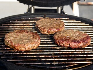 Beef burgers smoked and grilled on a barbeque over open flame