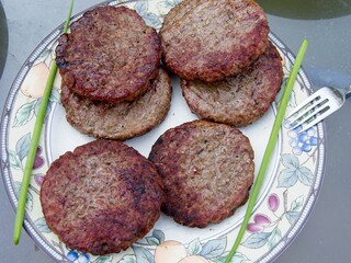 Beef burgers smoked and grilled on a barbeque over open flame