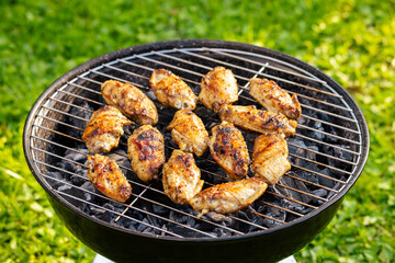 chicken wings grilling on charcoal grill
