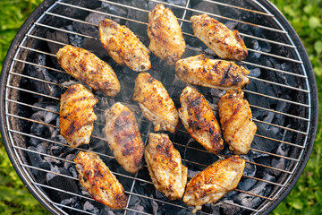 chicken wings grilling on charcoal grill