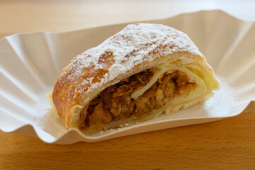 Sugared apple strudel on a paper tray.
