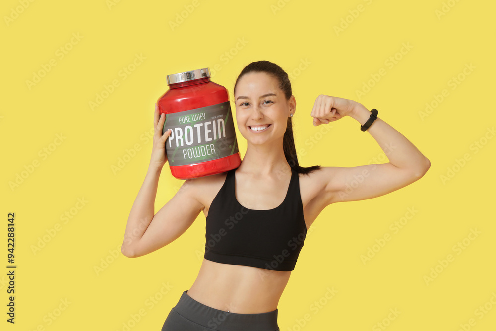 Poster sporty young happy woman with jar of protein powder showing muscles on yellow background