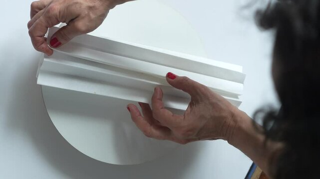 Women's hands lay out chocolates in a package