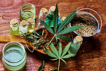 hemp seeds in a metal bucket, dried and raw hemp leaves in a large wooden dowel surrounded by jars...