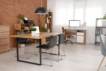 Interior of modern open space office with workplaces, chairs and shelving unit