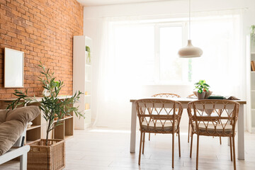 Interior of dining room with wooden table, chairs and hanging lamp