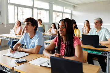Diverse young high school students listening to teacher in classroom. Education lifestyle and...