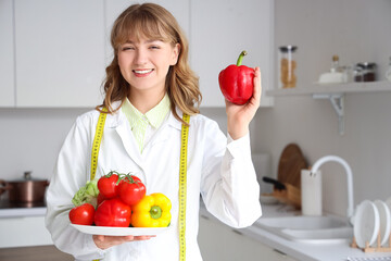 Female nutritionist with healthy food in kitchen