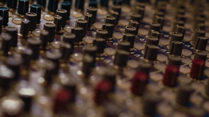 Pre amp knobs and switchers on mixing console panel board, audio stereo equipment used in music...