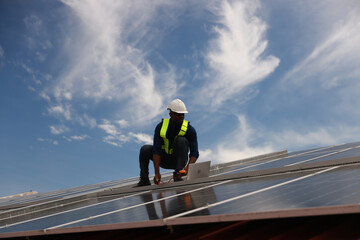 Fototapeta premium The black male Solar energy systems engineer performs analysis of solar panels at the solar farm