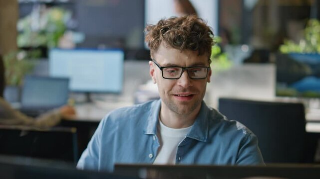 Smiling programmer working computer corporate workplace closeup. Man looking pc
