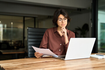 Busy serious young business woman manager working in office checking law document account invoice...
