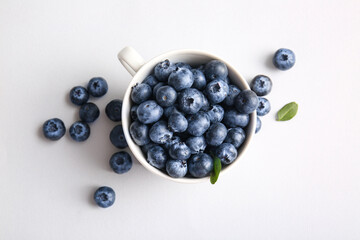 Cup of fresh ripe blueberry on white background, closeup
