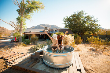 Two beautiful girls pose in a cowboy tub in Joshua Tree, California.