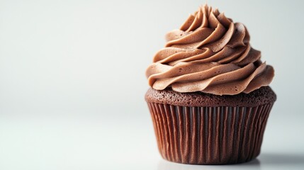 A chocolate cupcake with swirled frosting, set on a clean, white background with ample room for text.