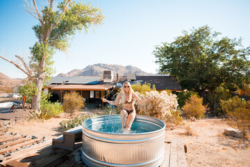 A beautiful blonde bathes in a cowboy bath on vacation. Joshua Tree, California