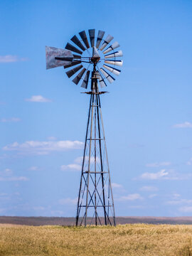 USA, Washington State, Palouse. Tall windmill in a field of wheat in summer.
