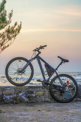 Fototapeta premium Bicycle on the beach barrier at sunset
