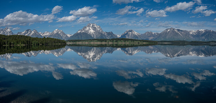 USA, Wyoming. Panoramic landscape of Teton peaks and clouds reflected in Jackson Lake, Grand Teton National Park