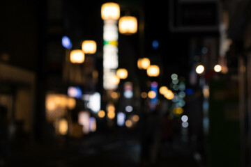 Bokeh background of city with buildings and neon billboard in the night