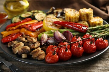 Delicious grilled vegetables served on wooden table, closeup