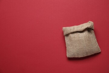 One burlap sack on red background, top view. Space for text