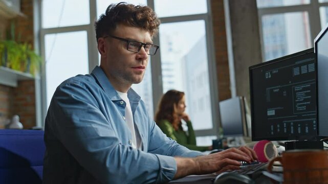 Eyeglasses developer typing keyboard writing code at office workplace closeup