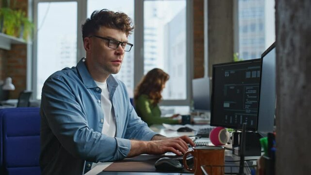 Focused man looking desktop at open space closeup. Freelancer working computer