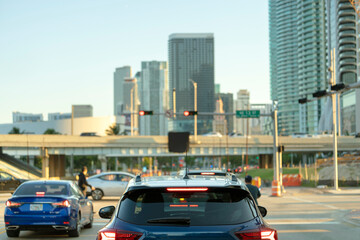 Cars traffic driving at intersection on American street with traffic lights in Miami, Florida. USA transportation